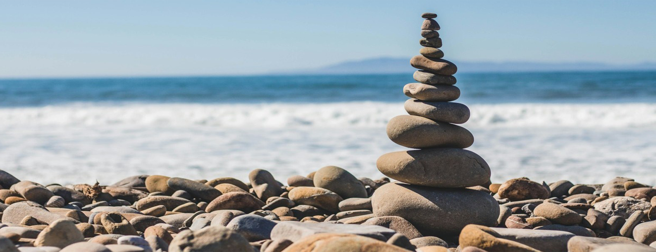 A stack of pebbles sitting on a pebble beach looking out to the sea